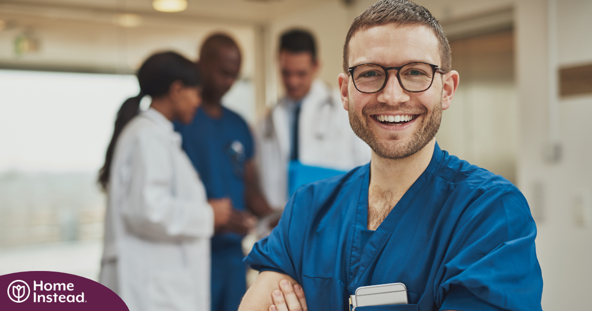 A young man in healthcare smiles, representing how a career as a professional caregiver can lead to a happy career as a healthcare professional.